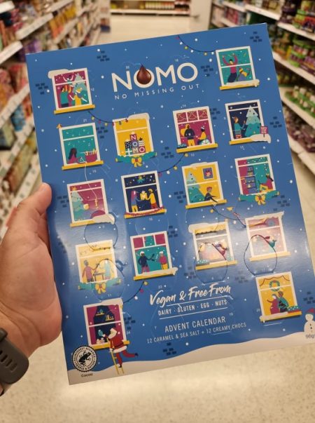 Hand holding Nomo advent calendar at supermarket