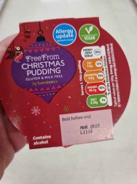 hand holding free from christmas pudding in the supermarket